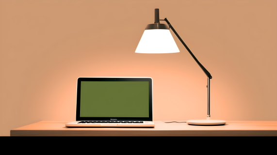 台灯照亮办公桌上的笔记本电脑摄影图片